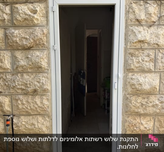 דלת אלומיניום מותקנת בקיר אבן חיצוני